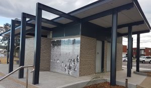 Public shower decorated with an outdoor tile mural