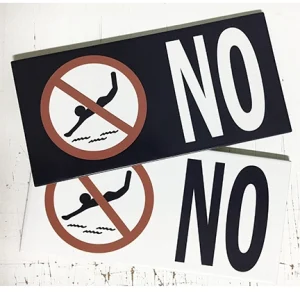 Pool safety tiles displaying custom warning messages in matching glazed porcelain finish.