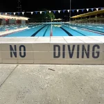 Custom pool safety message tile with durable kiln-fired ceramic finish in a residential pool.