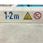 Swimming pool waterline featuring custom porcelain depth markers and decorative ceramic tiles.