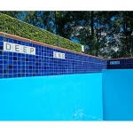 Glazed porcelain "Deep End" warning tile installed along the pool coping for safety.